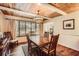 Inviting dining room featuring wood-look floors, windows overlooking the tree-filled property, and a wood paneled ceiling at 1438 Janmar Rd, Snellville, GA 30078