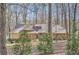 View of home's exterior showcasing stone accents, architectural roofline, and mature trees providing a private setting at 1438 Janmar Rd, Snellville, GA 30078
