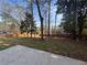 Spacious backyard featuring a large grassy area, mature trees, and a wooden fence at 2784 Williamsburg Way, Decatur, GA 30034