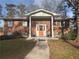 Charming brick home with a columned front porch and a vibrant orange front door at 2784 Williamsburg Way, Decatur, GA 30034
