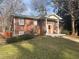 A charming brick home boasts an inviting front porch with classic columns at 2784 Williamsburg Way, Decatur, GA 30034