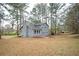 Back exterior of home with a large, grassy backyard and mature trees at 3201 Palomino Dr, Powder Springs, GA 30127