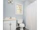 Cozy bathroom featuring a vanity, toilet, shower with curtain, and a window at 3201 Palomino Dr, Powder Springs, GA 30127