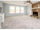 Spacious living room featuring a stone fireplace, carpet, and three windows at 3201 Palomino Dr, Powder Springs, GA 30127