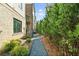 A gravel path runs along the side of a home with an air conditioning unit, and a row of trees at 235 Briscoe Way # 7, Alpharetta, GA 30009