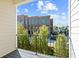 Lovely balcony view showing bright blue sky and a lush green treeline with a stately apartment building in the background at 235 Briscoe Way # 7, Alpharetta, GA 30009