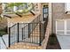 Stairway leading to the front door and second story balcony of a brick townhome with two car garage at 235 Briscoe Way # 7, Alpharetta, GA 30009