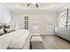 This bright main bedroom features a tray ceiling, neutral walls and flooring, and plush furnishings creating a peaceful retreat at 235 Briscoe Way # 7, Alpharetta, GA 30009
