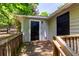 Wood deck featuring a black door to a storage area and wooden railing at 2949 Pearl St, East Point, GA 30344