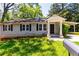 Charming home featuring green lawn, stone foundation, front porch and front yard at 2949 Pearl St, East Point, GA 30344