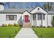 Beautiful white painted brick home with a red door and manicured landscaping at 4900 College St, Union City, GA 30291