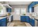 Bright kitchen with bold blue cabinets, stainless steel appliances, white countertops, and white subway tile backsplash at 4900 College St, Union City, GA 30291