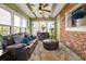 Comfortable sunroom with a brick accent wall, leather sofa, and a shaggy rug at 4900 College St, Union City, GA 30291