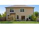 Spacious backyard featuring a well-maintained lawn, a patio with glass doors, and several windows at 5860 Bluff Heights Drive, Cumming, GA 30040