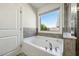 Bathroom features a soaking tub with tiled backsplash and natural light at 5860 Bluff Heights Drive, Cumming, GA 30040