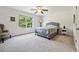 This spacious bedroom features neutral tones, a ceiling fan, and a large window for ample natural light at 5860 Bluff Heights Drive, Cumming, GA 30040