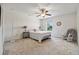 Bedroom with ceiling fan, rocking chair, and a large window overlooking landscaped yard at 5860 Bluff Heights Drive, Cumming, GA 30040