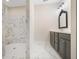 Bathroom with marble floors and shower, gray vanity and decorative mirror at 1011 Stillington Way, Kennesaw, GA 30152