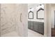 Elegant bathroom featuring marble tile, glass shower, and double vanity with ornate mirrors at 1011 Stillington Way, Kennesaw, GA 30152