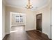 Elegant foyer with a dark wood door, chandelier, and beautiful hardwood floors at 1011 Stillington Way, Kennesaw, GA 30152