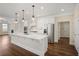 Bright open-concept kitchen with an island, stainless steel appliances, and hardwood floors at 1011 Stillington Way, Kennesaw, GA 30152