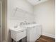 Bright laundry room with white washer, dryer, utility sink, and wire shelving at 1011 Stillington Way, Kennesaw, GA 30152