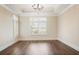 Living room with hardwood floors, plantation shutters, and a tray ceiling at 1011 Stillington Way, Kennesaw, GA 30152