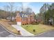 Corner view showcasing the brick home's curb appeal, long driveway and landscaping at 1811 Lake Cove Sw Dr, Atlanta, GA 30331