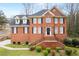 Traditional two-story brick home with black shutters, mature landscaping, and inviting front entry stairs at 1811 Lake Cove Sw Dr, Atlanta, GA 30331