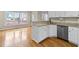 Kitchen featuring white cabinetry, stainless steel dishwasher, and hardwood floors at 1811 Lake Cove Sw Dr, Atlanta, GA 30331