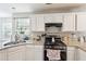 Kitchen with granite countertops, stainless steel sink and a gas range with white cabinetry at 2770 Da Vinci Cres, Decatur, GA 30034