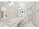 Bathroom with wallpaper, a double-sink vanity, and an adjacent doorway leading to a separate shower/tub at 303 Brandywine Cir, Atlanta, GA 30350