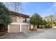 Charming townhome featuring a two-car garage, a balcony, and mature trees surrounding the property at 303 Brandywine Cir, Atlanta, GA 30350