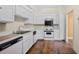 Efficient white kitchen featuring matching appliances, ample cabinets, and hardwood floors at 303 Brandywine Cir, Atlanta, GA 30350
