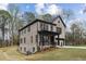 Exterior view of a home with a walkout basement, brick facade, and large windows overlooking a wooded lot at 346 Langford Dr, Norcross, GA 30071