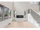 Bright living room featuring a modern fireplace, large windows, and a staircase with black railings at 346 Langford Dr, Norcross, GA 30071
