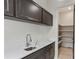 A walk-in pantry with dark brown cabinets and marble countertops and hardwood floors at 346 Langford Dr, Norcross, GA 30071