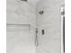 Marble-tiled shower with pebble flooring, rainfall showerhead, and handheld sprayer at 346 Langford Dr, Norcross, GA 30071
