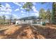 Wide shot of the backyard featuring trees and a white-painted brick home with a fenced-in patio at 1937 Joseph Ct, Decatur, GA 30032