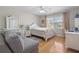 Sunlit bedroom with hardwood floors, light-colored furniture and a cozy sitting area at 3346 Stonecrest Ct, Atlanta, GA 30341