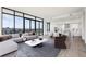 Modern living room featuring sleek furnishings, large windows with a city view, and hardwood floors at 2425 Peachtree Ne Rd # 1705, Atlanta, GA 30305