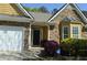 Close-up of a charming home featuring stone and shingle accents, well-manicured landscaping, and an attached two-car garage at 5250 Fieldgate Ridge Dr, Cumming, GA 30028