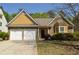 Charming home featuring stone and shingle accents, well-manicured landscaping, and an attached two-car garage at 5250 Fieldgate Ridge Dr, Cumming, GA 30028