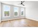 Bright bedroom with hardwood floors, ceiling fan and three windows with wooded views at 7230 Summit Pl, Alpharetta, GA 30009