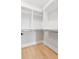 Walk-in closet with custom shelving and hardwood floors at 7230 Summit Pl, Alpharetta, GA 30009