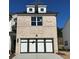 Charming townhome with a two-car garage, brick facade, and dormer windows at 255 Depot Landing Rd # 38, Auburn, GA 30011