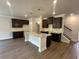 Modern kitchen featuring a large island with granite countertops and dark wood cabinets at 255 Depot Landing Rd # 38, Auburn, GA 30011