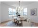 Light filled dining room with a modern chandelier, light walls, and wood floors at 3395 Lee St, East Point, GA 30344