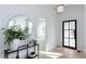 Light and airy foyer with wood floors, black framed door and modern accents at 3395 Lee St, East Point, GA 30344