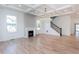 Bright, open living room with coffered ceilings, hardwood floors, fireplace, and staircase at 3395 Lee St, East Point, GA 30344